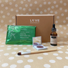 Subscription box  with TUSOL matcha smoothie mix, Vielle Serum bottle, Orglamix brush, and Flyte.70 Eyeshadow on a polka dot background.