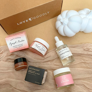 Collection of skincare products and a box with 'Love Goodly' branding on a beige surface.